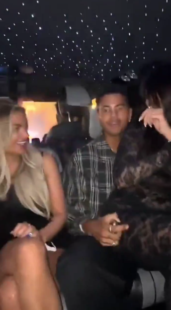 Three people, two men and a woman, riding in a car with a "starlight" ceiling.