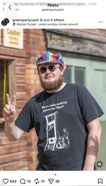 A man wearing a rainbow-colored cap and sunglasses gives a peace sign, wearing a black T-shirt that reads "We're only making plans for Nigel."