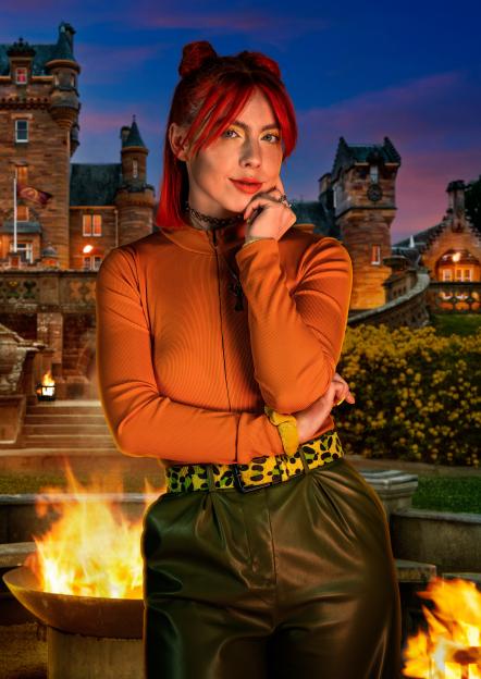 Jessie, a 28-year-old hairstylist from Hull, posing in front of a castle and a firepit.