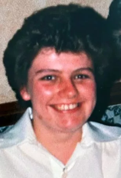 Joy Boulton smiling in a white collared shirt.