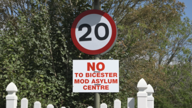 A speed limit sign showing 20 MPH, with a sign below it that reads, "NO TO BICESTER MOD ASYLUM CENTRE".