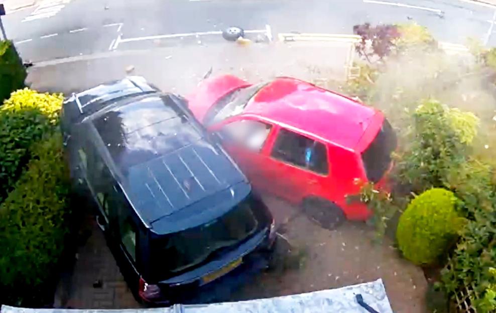 A red car crashed into the front garden and collided with a parked black car.