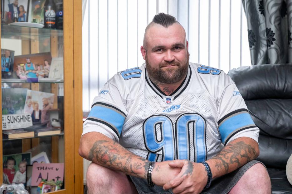 Lottery winner Michael Carroll, also known as Mikey Carroll, sitting on a couch.