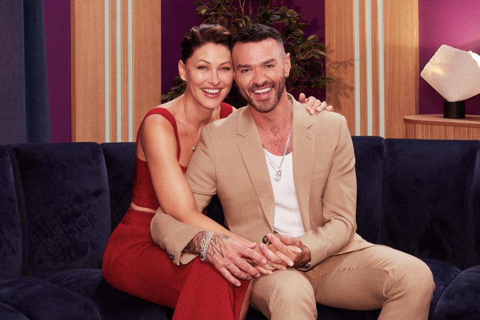Emma and Matt Willis, hosts of Love Is Blind: UK Season 2, smiling on a couch.