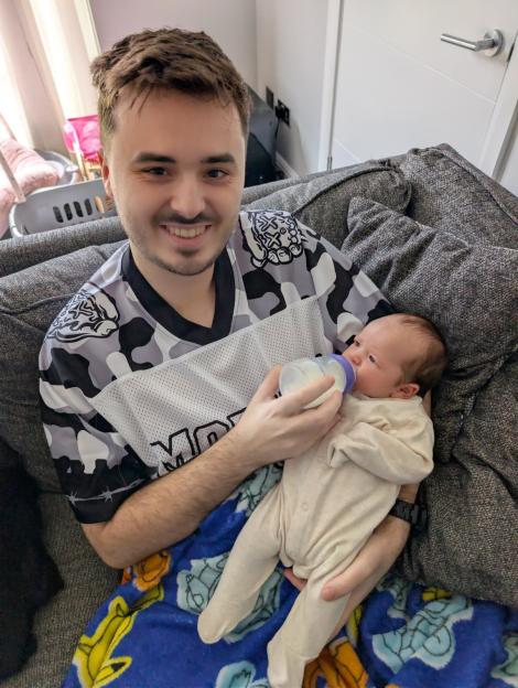 Sam King feeding his daughter Sophie a bottle.