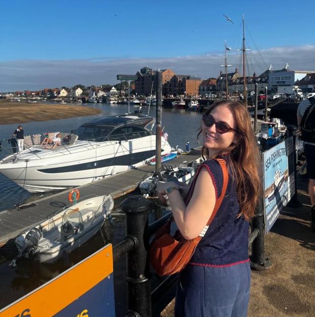 Alice Penwill smiling at the Wells-Next-The-Sea harbor.