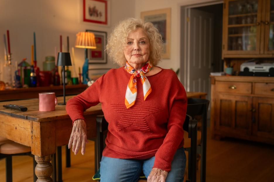 Amy Price seated, facing forward, in a domestic setting.