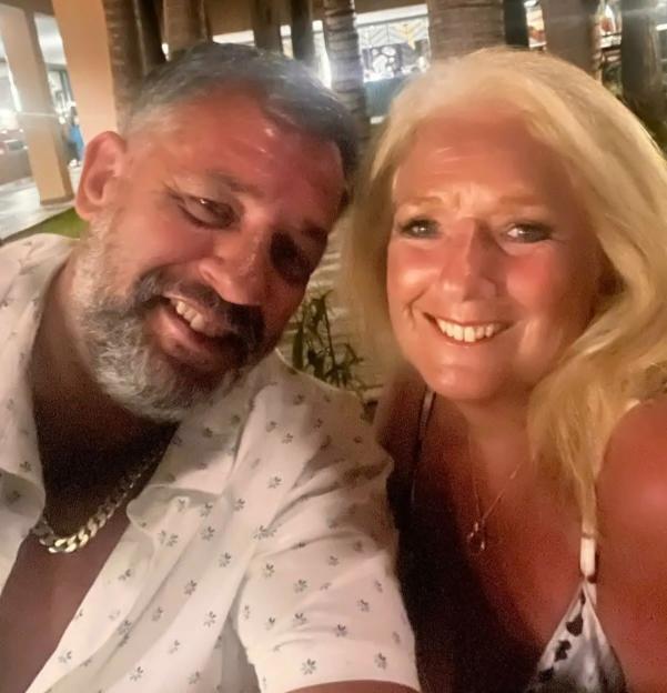 A man with a beard and a woman with blonde hair smiling for a selfie at night.