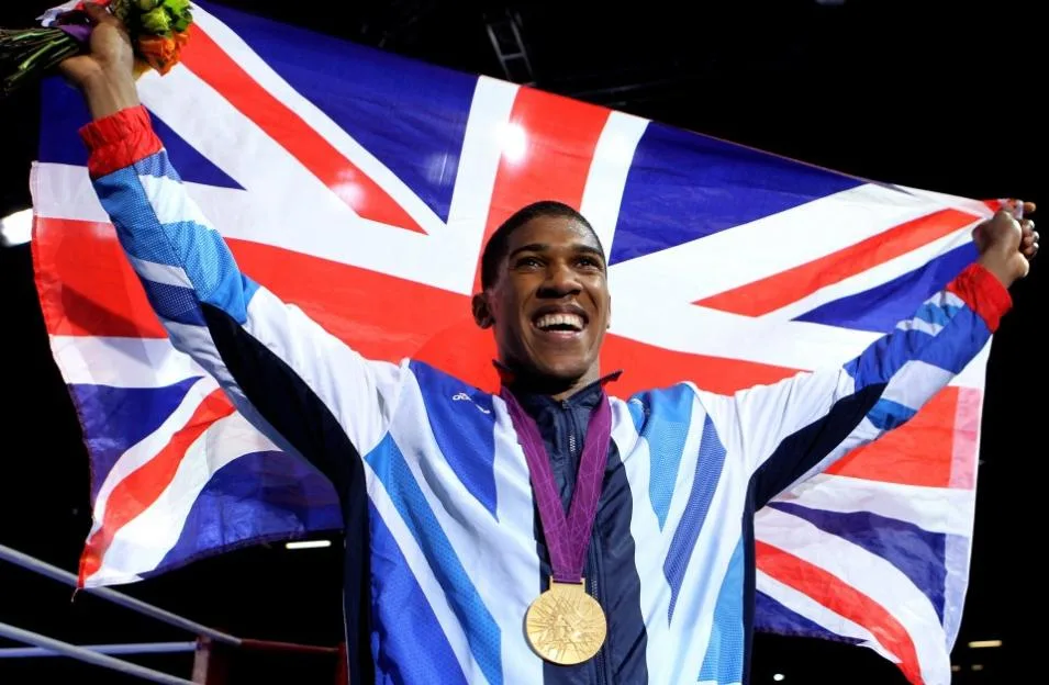Great Britain's Anthony Joshua celebrates with his Gold medal holding the British flag at the Olympic Games.