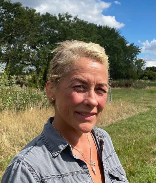 Sarah Beeny smiling with her new short blonde hair after donating it to charity.