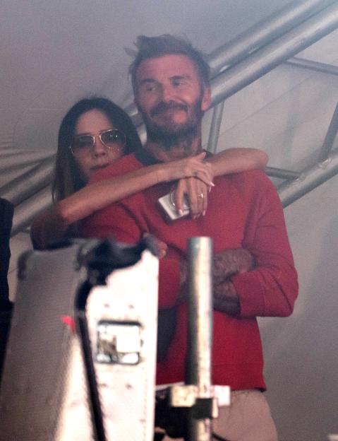 Sir David Beckham and Lady Victoria Beckham embracing while watching their son Cruz perform at Reading Festival.
