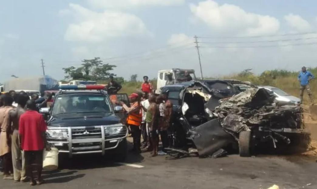 A black SUV with flashing lights at a car crash site.