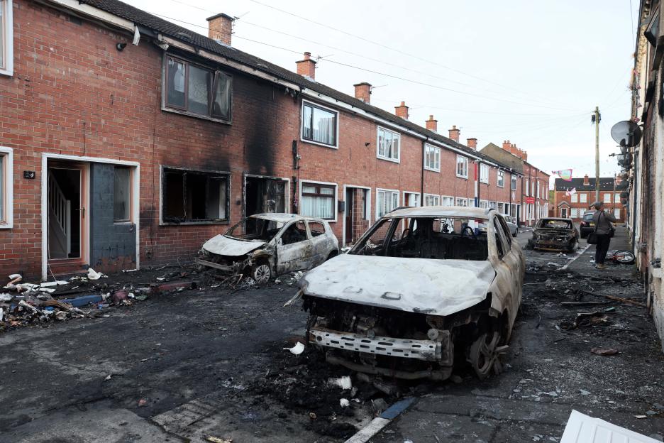 Street in East Belfast showing clear-up after arson attacks on homes and cars.