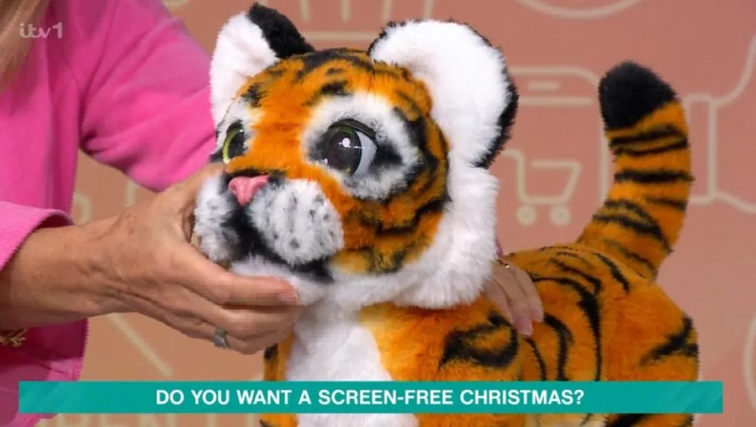 A robotic toy tiger being petted.