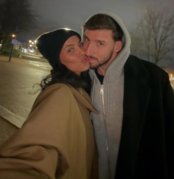 Maya Jama kissing Ruben Dias on the cheek.