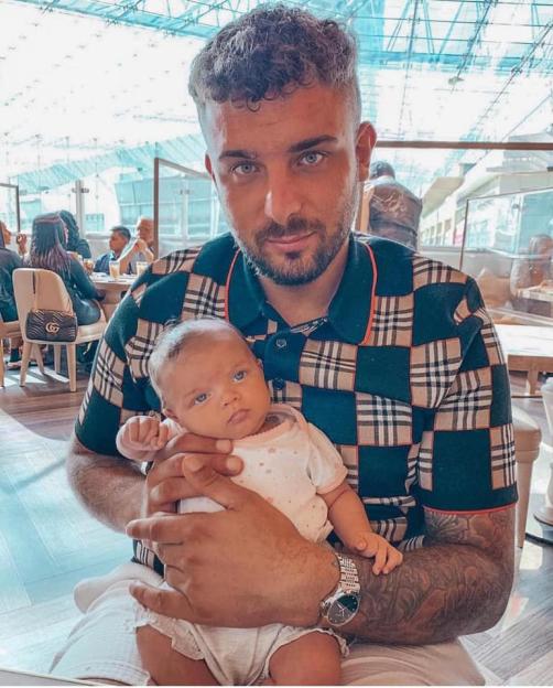 Ali Watson holding his baby.