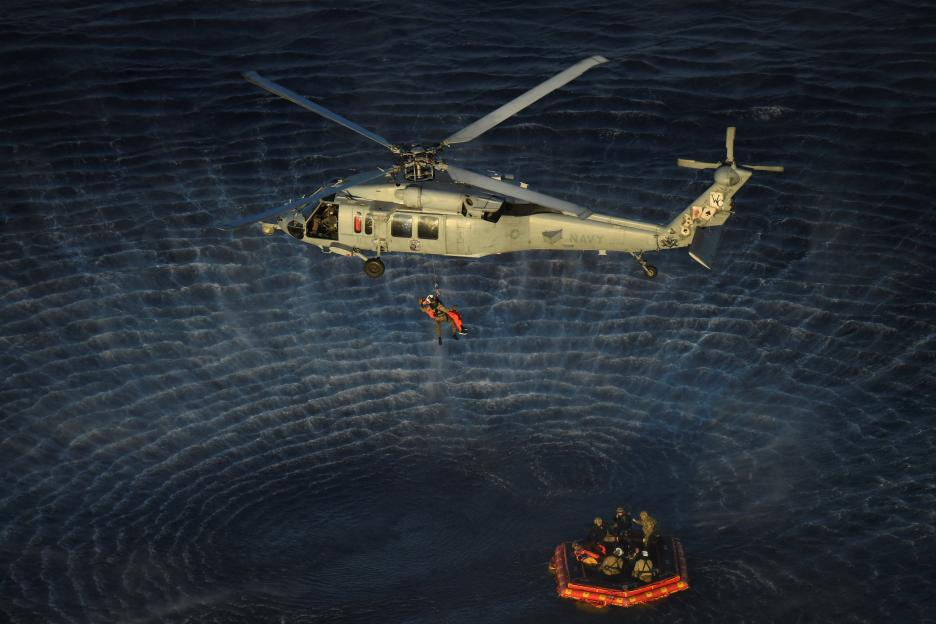 Artemis II astronauts are hoisted into a U.S. Navy MH-60 helicopter from a rescue dinghy after splashdown