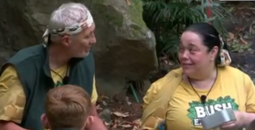 Two people in yellow shirts in a jungle setting.