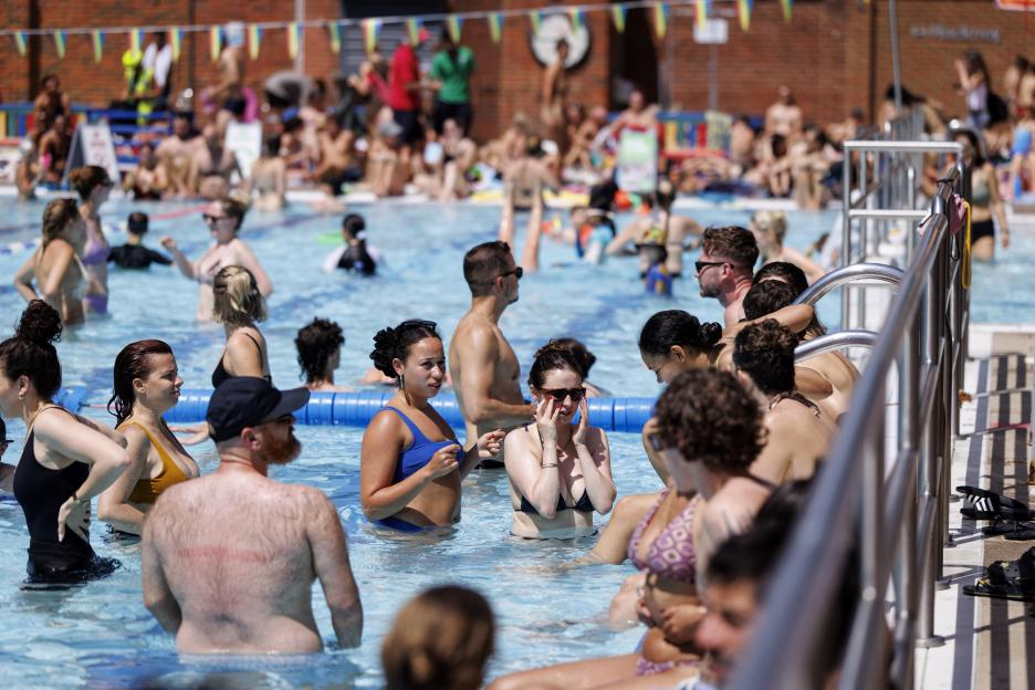 People cooling off in a swimming pool during a heatwave.