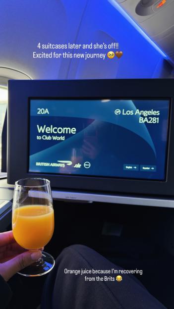 Sophie Piper on a British Airways flight to Los Angeles in Club World, holding a glass of orange juice.