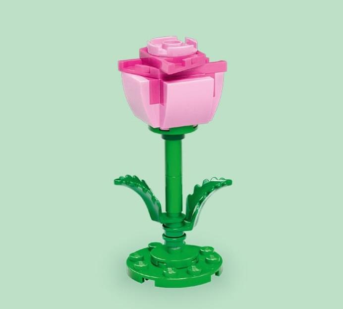 LEGO pink rose with green stem and leaves on a green background.