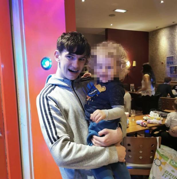 Tyler Kerry holding a blurred child.