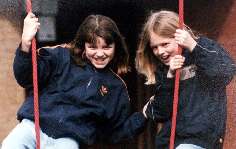 Two young girls, Jessica Chapman and Holly Wells, smiling on a swing.