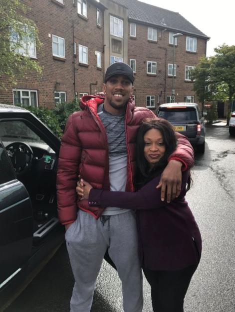 Anthony Joshua hugging his mother in front of an ex-council flat.