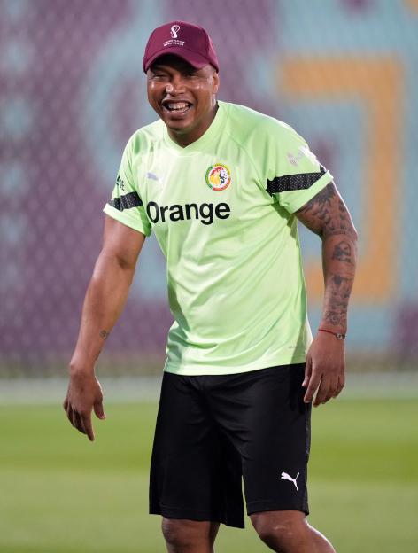 El Hadji Diouf wearing a lime green training shirt and a FIFA World Cup Qatar 2022 cap.