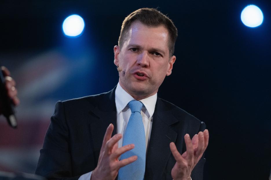 Robert Jenrick MP speaks on stage at the National Exhibition Centre.