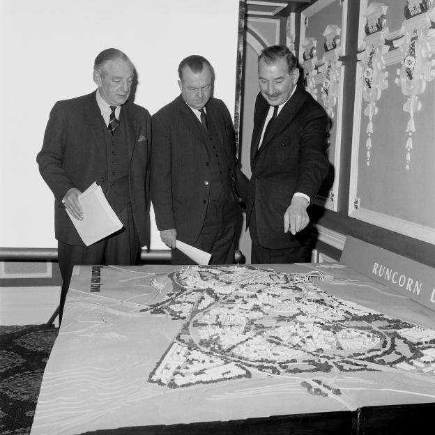 V.A Arnold, chairman of the Runcorn Development Corporation (left) and D.F Banwell, the general manager (centre) and professor Arthur Ling, consultant architect-planner for the project, looking at a model of the proposed Runcorn New Town at a press c