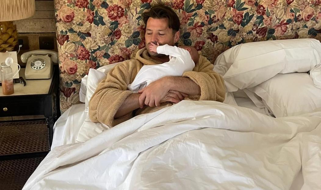 Mark Wright with baby Palma in bed.