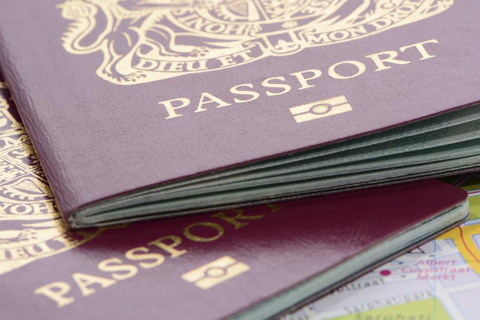 Two United Kingdom biometric passports on a road map.