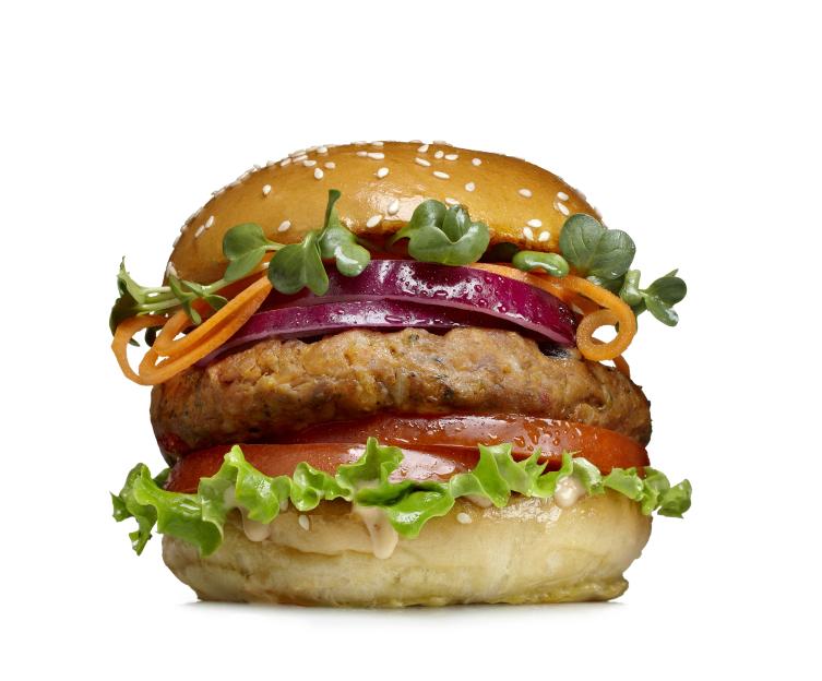 Veggie burger with red onions, sprouts, and tomatoes.