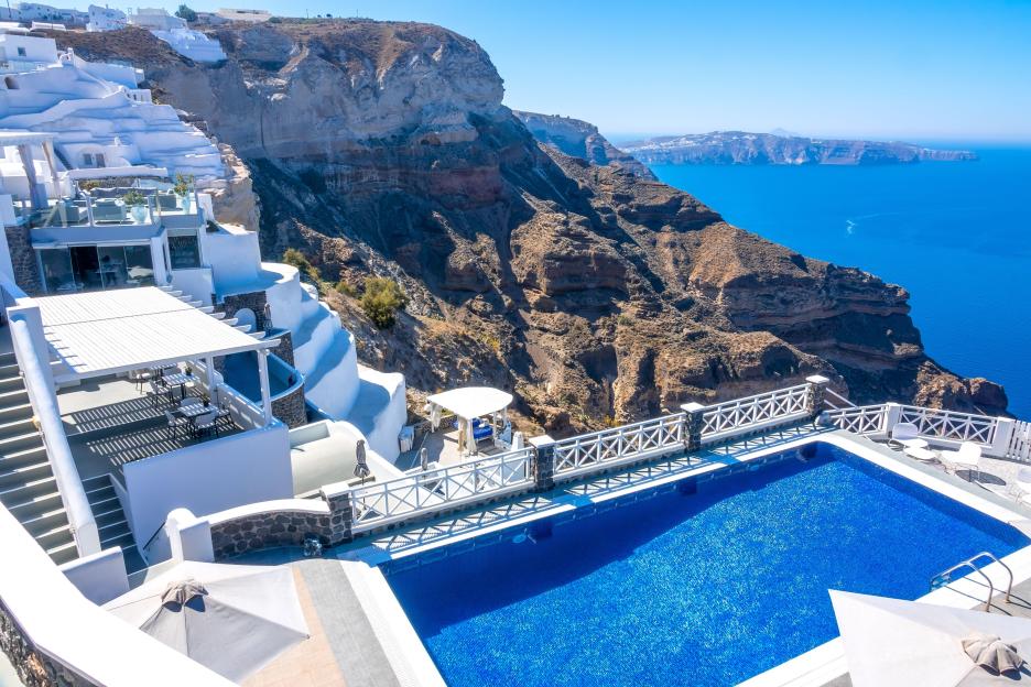 A villa with a pool overlooking the caldera in Santorini, Greece.