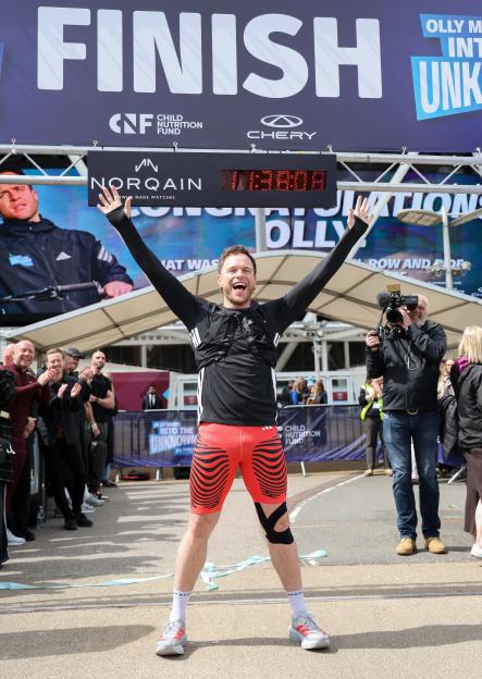Olly Murs celebrates crossing the finish line of his 400km endurance challenge.