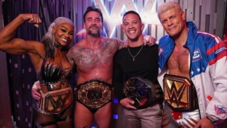 WWE wrestlers posing with championship belts.