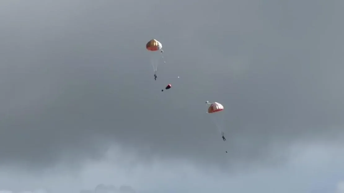 Pilots ejecting by parachute after a Hawk T2 training aircraft crashes near RAF Valley.